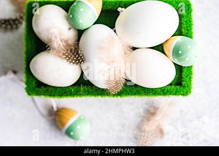 Overhead view of eggs and Easter egg decorations in a carton Stock Photo