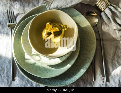 Overhead view of a festive Easter place setting with a golden Easter bunny Stock Photo