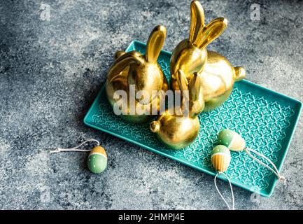 Festive golden Easter bunny decorations on a table with Easter eggs Stock Photo