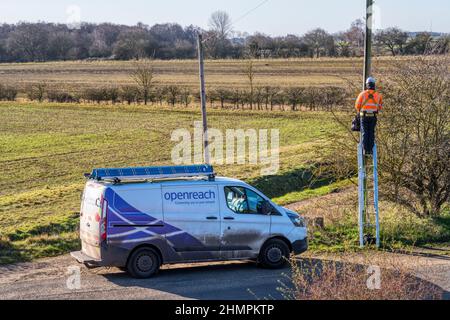 BT Openreach engineer up a pole working on a line in rural Norfolk countryside. Stock Photo