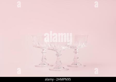 Three vintage crystal glasses for sparkling wine or champagne on pastel pink background.Summer drink concept. Minimal creative composition with copy space. Stock Photo