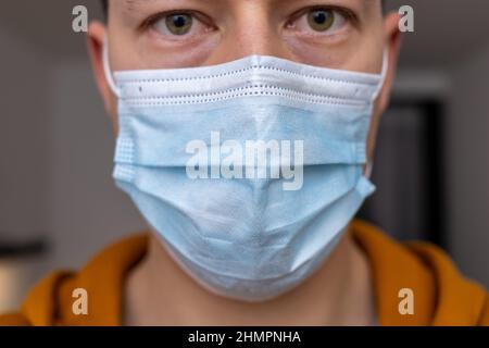man with sad eyes in blue face mask Stock Photo