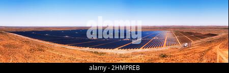 Whole solar power generation plant with solar panels on red soil of Australian outback at Broken HIll city in aerial panorama. Stock Photo