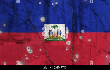 Full frame photo of a weathered flag of Haiti painted on a cracked wall with bullet holes. Stock Photo