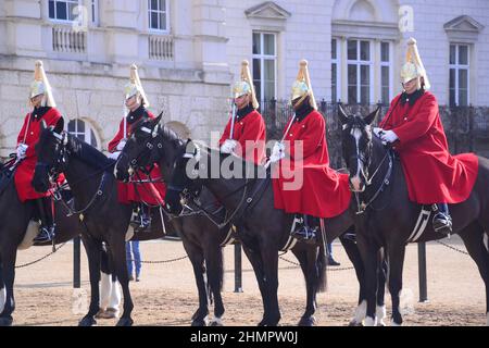 The Queen's Life Guard change ceremony on Horse Guards Parade, off Whitehall, London, United Kingdom, British Isles. Soldiers of the Household Cavalry Mounted Regiment, the Life Guards, who wear red tunics and white plumed helmets. Horse Guards, named after the troops who have protected the Sovereign since the Restoration of King Charles II in 1660, is today the official entrance to Buckingham Palace and St James's Palace. Stock Photo