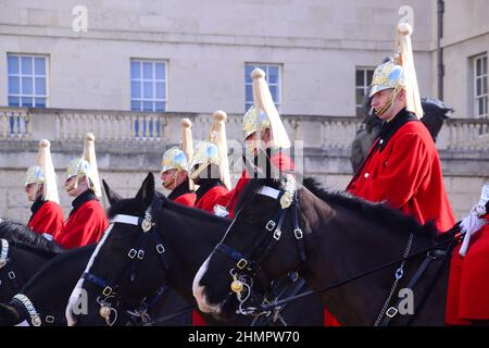 The Queen's Life Guard change ceremony on Horse Guards Parade, off Whitehall, London, United Kingdom, British Isles. Soldiers of the Household Cavalry Mounted Regiment, the Life Guards, who wear red tunics and white plumed helmets. Horse Guards, named after the troops who have protected the Sovereign since the Restoration of King Charles II in 1660, is today the official entrance to Buckingham Palace and St James's Palace. Stock Photo