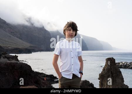 Portrait of a teenager against the backdrop of the Los Gigantes cliffs. Tenerife. Canary Islands. Spain. Stock Photo