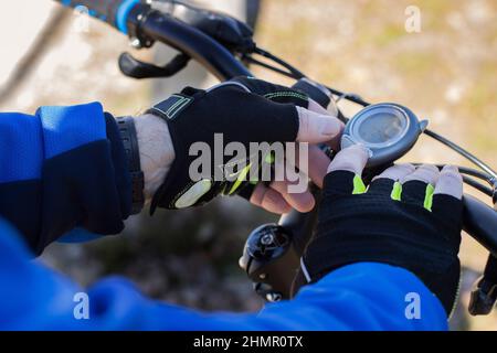 close up middle-aged bicyclist's hands using a stopwatch Stock Photo
