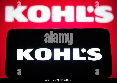 In this photo illustration, a Kohl's Corporation logo is seen on a smartphone and a computer screen. Stock Photo