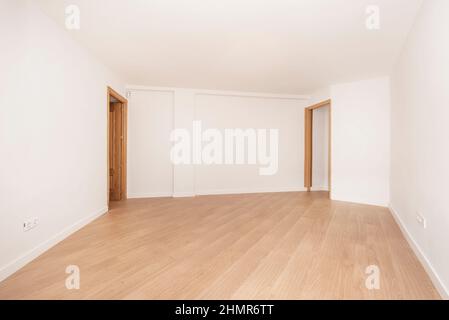 Large empty room with two oak doors and light colored wooden flooring Stock Photo