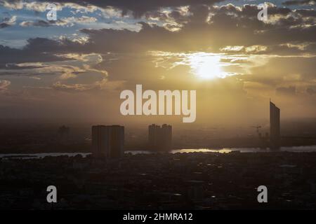 Gorgeous scenic over large metropolitan of Bangkok city overlooking skyscrapers with orange sky and the Bridge crosses the Chao Phraya river before su Stock Photo