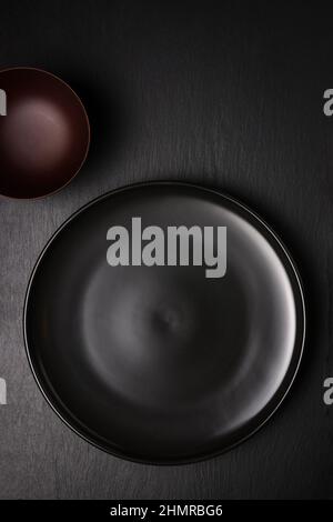 empty black plate and a cup on a slate surface, food photography background or backdrop, top view with copy space Stock Photo
