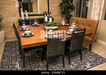Square Wooden Dining Room Table With Eight Place Settings Stock Photo