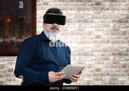 Businessman with vr goggles holding virtual meeting in office using metaverse blockchain technology app Stock Photo
