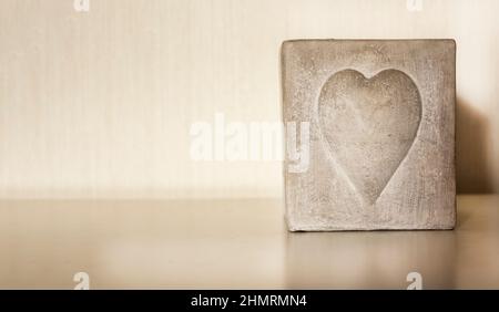white square candle with a heart on a white background Stock Photo