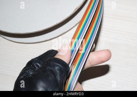 Coil of multi-colored wires in hand close up Stock Photo