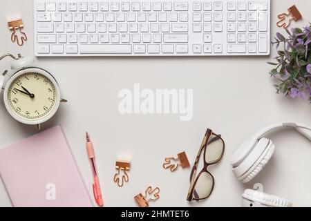 Desktop. Notepad keyboard alarm clock glasses headphones on the table. Frame with copy space Stock Photo