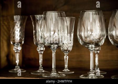 various clean wine glasses on the shelf of an old rustic cabinet Stock Photo