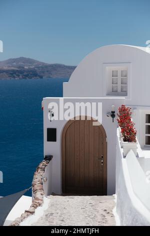 Beautiful brown door on white facade of greek architecture hotel in Oia city, Santorini island, Greece, Europe. Beautiful details of the island of San Stock Photo