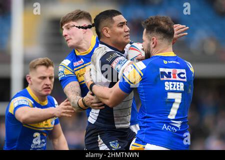 Peter Mata’utia #3 of Warrington Wolves is tackled by Liam Sutcliffe #4 and Aidan Sezer #7 of Leeds Rhinos Stock Photo