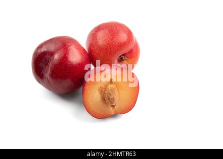 horizontal photo of plums, one cut in half showing the stone. isolated on a white background with copy space Stock Photo