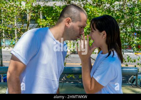 A Young latin couple or married couple having a heated fight in the street. Concept of fight, heartbreak, couple, discussion. Stock Photo