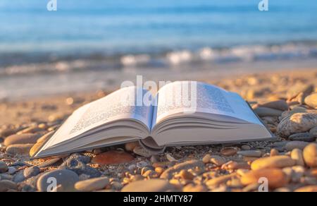 Zenitude on the beach. Open book on a beach with sunset. Stock Photo