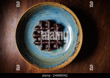 Chocolate waffle in handmade clay bowl Stock Photo