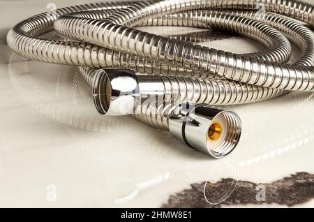 Shower chrome hose and fittings close-up on a white background. Stock Photo