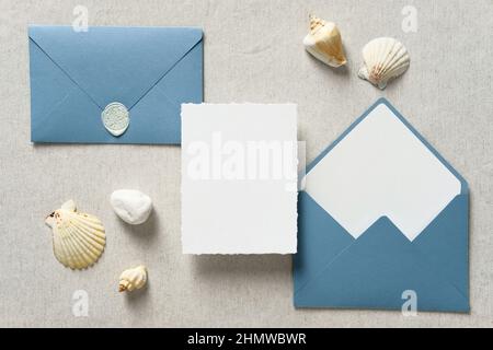 Nautical wedding invitation card mockup and blue envelopes with seashells on pastel beige background. Wedding stationery set. Sea, marine concept. Stock Photo