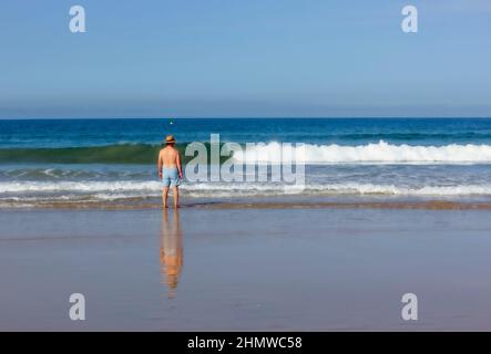 Solitary man looking out to sea Stock Photo