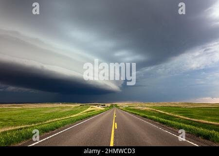 Dark dramatic storm clouds over a road near Glendive, Montana Stock Photo
