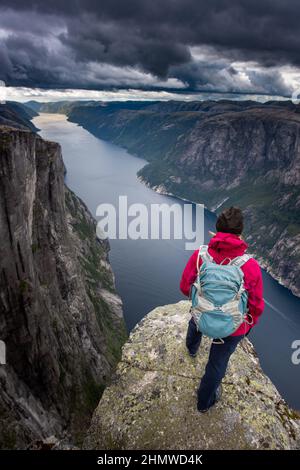 Visiting Norway, Backpacker on top of Eagle Head Viewpoint near Kjeragbolten Stock Photo