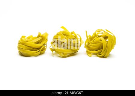 Spinach noodle pasta nests in a row Stock Photo