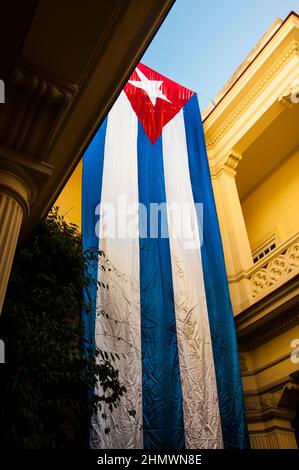 Large Cuban flag hangs in the offices of CENESEX, an organization for LGBTQ equality upon the death of Cuban leader Fidel Castro in Havana, Cuba. Stock Photo