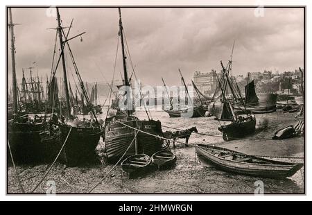 Vintage 1890s Scarborough fishing harbour at low tide, with The Grand Hotel Scarborough on the skyline in background North Yorkshire, England.UK Stock Photo