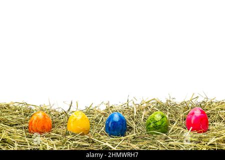 colorful easter eggs in a row on hay Stock Photo