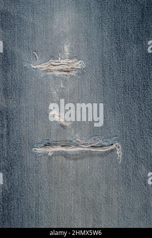 Detail of blue jeans canvas ripped, with holes, distressed, faded and damaged for backgraund Stock Photo