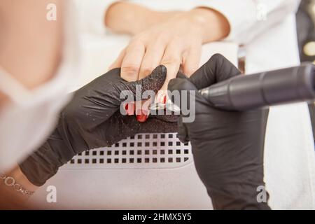 Manicure master removing shellac from client nails Stock Photo