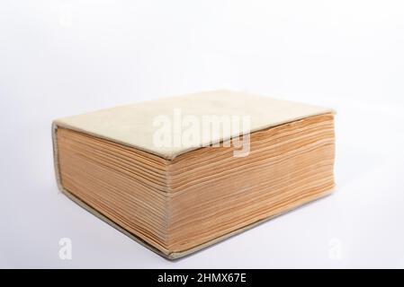 Old book with yellowed pages and a cloth cover. Thick book isolated on a white background. Stock Photo