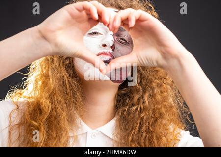 Photo of pretty foxy lady redhead with face painted in Qatar flag making heart sign using two hands as love for her favourite team. Stock Photo