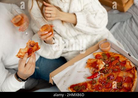 Delicious fragrant pizza and wine in glass glasses gives pleasure to couple in love on romantic date. Pleasure of eating. Excellent appetite Stock Photo