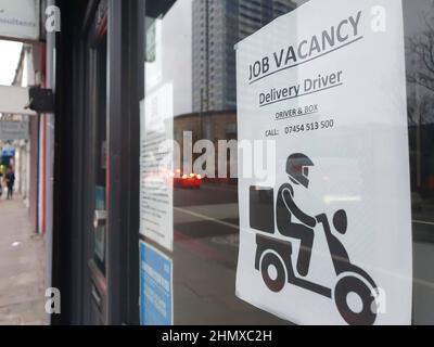 London, UK, 7 February 2022: a take-away food restaurant in Battersea has a sign in the door advertising a job vacancy for a delivery driver. Anna Wat Stock Photo