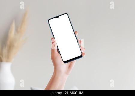 Female hand holding smart phone with blank mockup screen Stock Photo