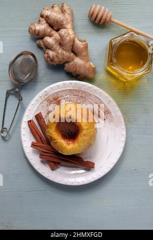 Baked apple with honey, cinnamon and ginger on a light wooden table Stock Photo