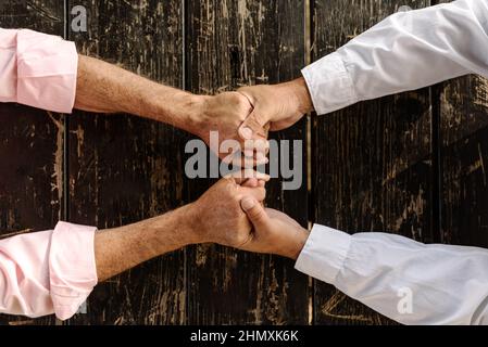 Top view of a loving gay couple holding hands while sitting on a table. Stock Photo