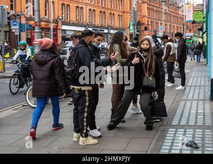 A French female student gives a thumbs up as her group of friends look at an injured pigeon in Grafton Street, Dublin, Ireland.  Ireland is a popular Stock Photo