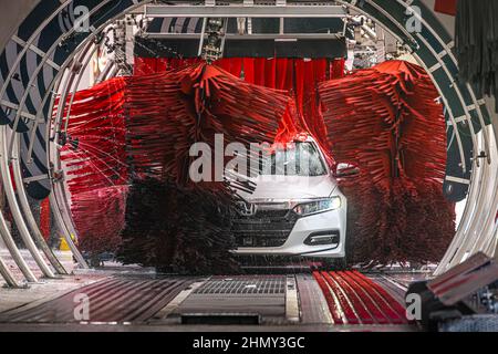 White Honda in a modern automated car wash system at Tommy's Express Car Wash in Snellville, Georgia, just east of Atlanta. (USA) Stock Photo