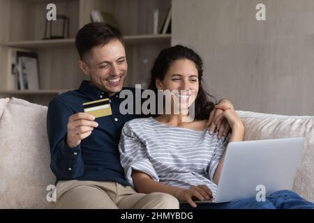 Happy millennial married couple shopping on internet together Stock Photo