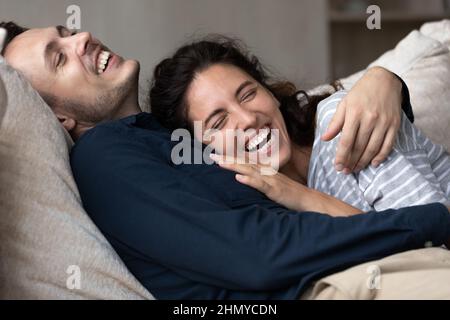 Joyful millennial couple having fun and enjoying closeness at home Stock Photo